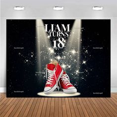 a pair of red sneakers sitting on top of a wooden floor next to a wall