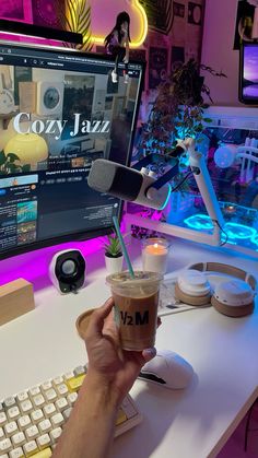 a person is holding a drink in front of a computer screen and keyboard with the word cozy jazz on it