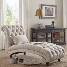 a gray chaise lounge chair sitting on top of a rug