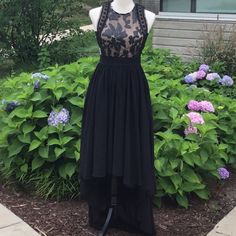 a dress on display in front of some bushes