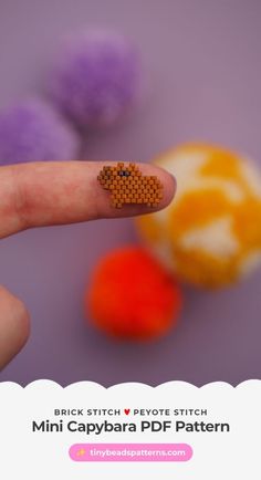 a tiny beaded heart on the tip of a finger