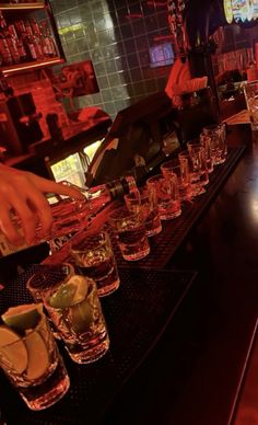 the bartender is pouring drinks into glasses on the bar counter at the restaurant or bar