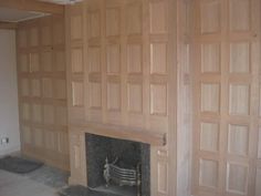 an empty room with wood paneling and a fire place