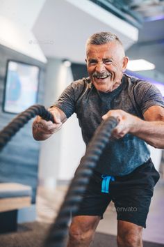 an older man working out with a rope in the gym - stock photo - images