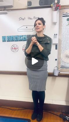 a woman standing in front of a white board