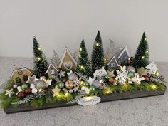 an arrangement of christmas trees and ornaments on a table