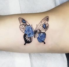 a butterfly tattoo with blue roses on it