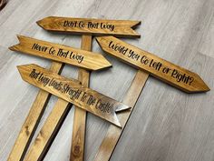 four wooden signs pointing in different directions on a wood floor with the words don't be that way