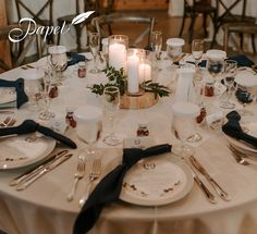 a table set for dinner with candles and place settings