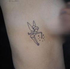 a small fairy tattoo on the side of a woman's right arm and chest