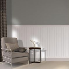 a chair and table in a room with gray walls, white wainscoting and striped curtains