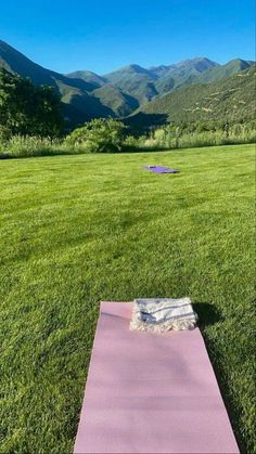 a yoga mat laying on top of a lush green field