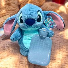 a blue stuffed animal sitting on top of a bed next to a baby bib