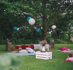 an outdoor party with pillows and decorations on the grass