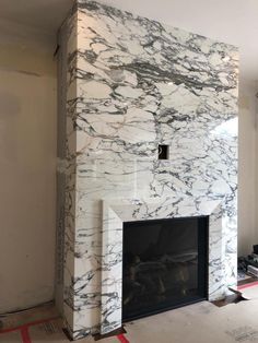 a white marble fireplace in the middle of a room