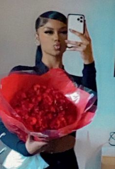 a woman taking a selfie with her cell phone and holding a bouquet of flowers