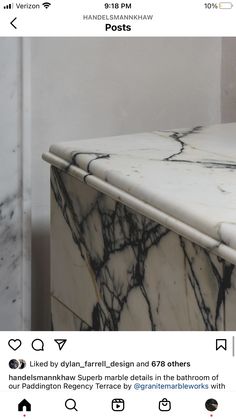 a marble table with black and white veining on the top, next to a wall