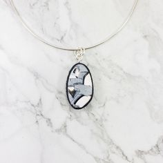 Discover the unique beauty of the 3/4" x 1-1/4" (20mm x 32mm) Calacatta Oval Pendant! This exquisite piece blends black, white and silver for a marbled look sure to turn heads. Includes an 18" sterling silver chain, but other chain lengths can be arranged. White Oval Pendant With Polished Finish, White Oval Pendant Necklace With Polished Finish, Unique Black Oval Pendant Necklace, Adjustable Oval Silver Necklace, Modern Oval Large Pendant Jewelry, Modern Silver Oval Pendant Jewelry, Unique White Oval Pendant Necklace, Silver Adjustable Necklace With Oval Pendant, Adjustable Silver Necklace With Oval Pendant