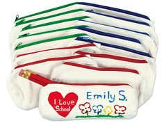 six pairs of personalized baby diapers with hearts and flowers on the bottom, one for each child