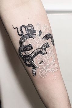 a black and white snake tattoo on the arm