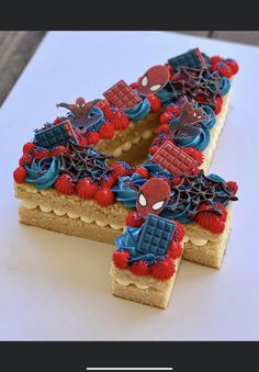 a cake shaped like the letter e with spiderman decorations on it's edges