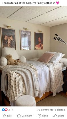 a bedroom with pictures on the wall and a teddy bear sitting at the end of the bed