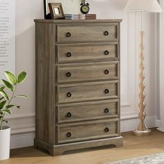 a wooden dresser sitting next to a lamp on top of a hard wood floor