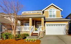 a large house with two garages and stairs leading to the front door on a sunny day