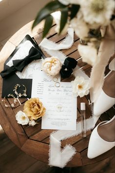 a table topped with lots of different types of flowers and wedding rings on top of it