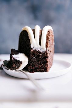 a piece of chocolate cake with white icing on a plate