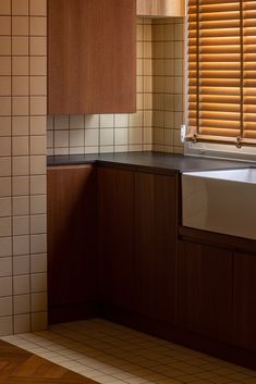 a kitchen with wooden cabinets and white tile