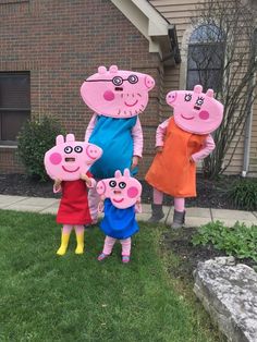 three people in peppa pig costumes standing on the grass with two children and one adult