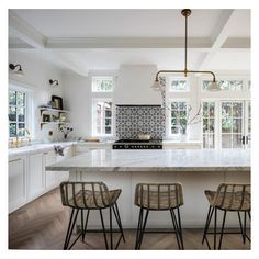 three chairs sitting in front of a kitchen island