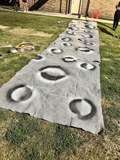 a long sidewalk with circles on it in the grass