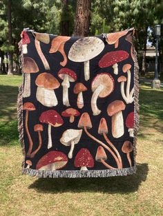 a blanket that has mushrooms on it in the grass