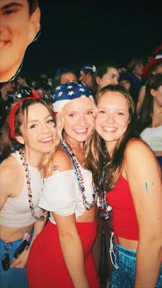 three girls are posing for the camera in front of a crowd