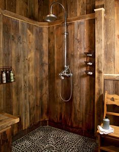 a bathroom with wooden walls and a shower head in the corner next to a bench