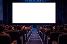 people sitting in chairs watching a movie on a large screen at the end of an auditorium