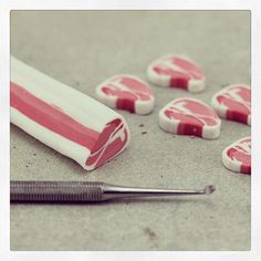 several red and white candies are laying on the ground next to a screwdriver