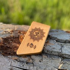 a wooden case sitting on top of a piece of wood with an om sign in the middle