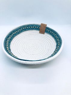 Enjoy this holiday treat. One-of-a-kind handmade small rope bowl with boho trim.  They are handmade with 100% cotton rope and thread. These bowls can be used as a jewelry dish. Description: Natural rope bowl w/blue trim Bowl Dimensions (Aprox.) Base: Aprox. 3" Height: 1" Diameter: 5.5" Care Instructions:  Spot clean with a gentle soap or simply hand wash and air dry. Gentle warm iron if needed. Coiled Rope Basket, Bowls Ideas, Rope Bowls, Basket Gifts, Coiled Rope, Rope Basket, Blue Trim, Jewelry Dish, Cotton Rope