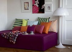 a living room filled with lots of furniture and pictures on the wall above it's headboard