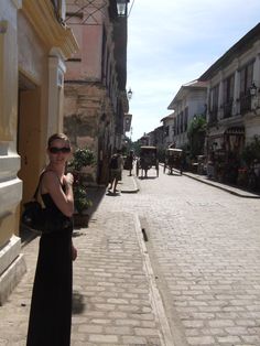 a woman standing in the middle of an empty street