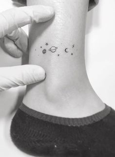 a person with a small tattoo on their ankle that has the moon and stars above them