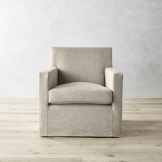 a beige chair sitting on top of a wooden floor