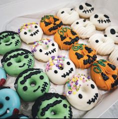 a box filled with lots of decorated donuts in the shape of skulls and skeletons