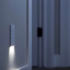 an illuminated door handle on the side of a white door in a room with two doors