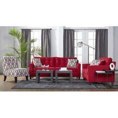 a living room with red couches, chairs and a table in front of a window