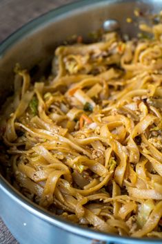 a pan filled with noodles and vegetables on top of a table