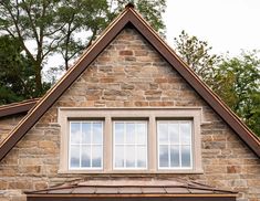 a brick building with two windows and a brown roof